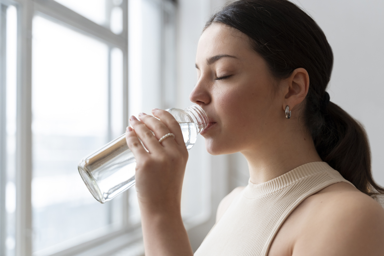 Mujer bebiendo agua y calmando la sed