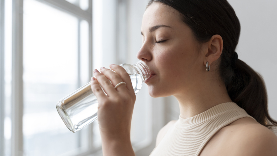 Mujer bebiendo agua y calmando la sed